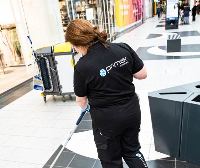 Lokalvårdare utför golvstäd i galleria